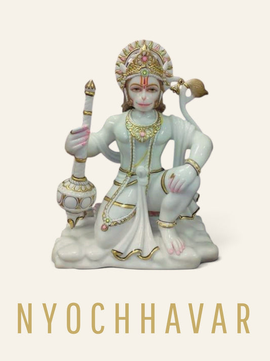 White marble Hanuman Ji murti kneeling with his gada resting beside him and gold detailing on the crown and jewellery