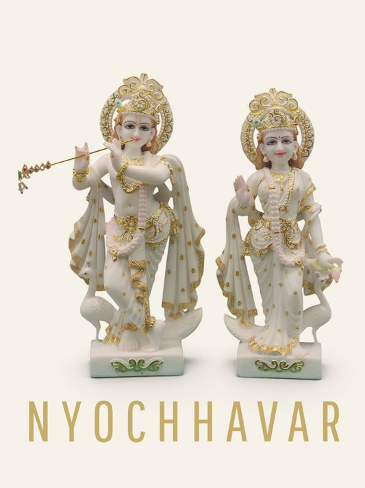 White marble Radha Krishna statue pair with gold detailing, carved halos and peacocks at the base