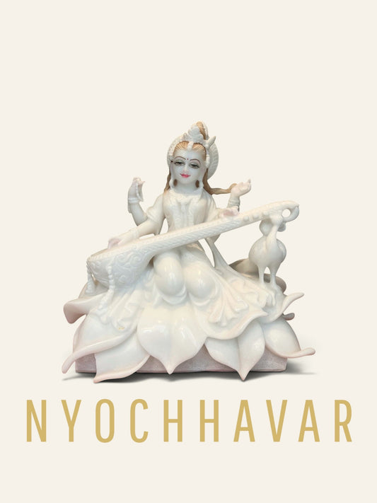White marble Saraswati Ji statue seated on a carved lotus playing the veena with a swan beside her
