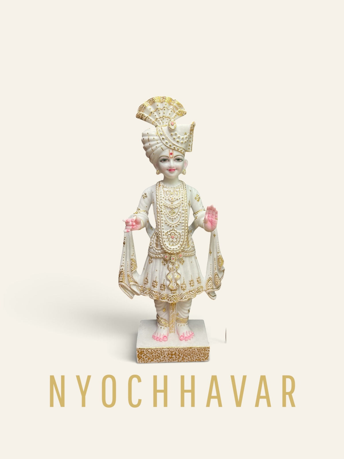 White marble Swaminarayan murti with gold detailing on the turban and robes, standing with raised hand